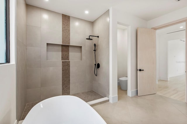 bathroom featuring toilet, tile floors, and plus walk in shower