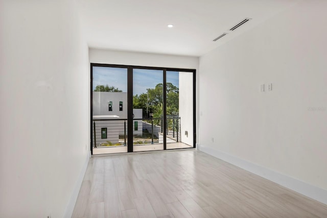 empty room featuring plenty of natural light and light hardwood / wood-style flooring