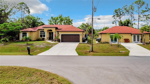 mediterranean / spanish home featuring a front lawn, french doors, and a garage