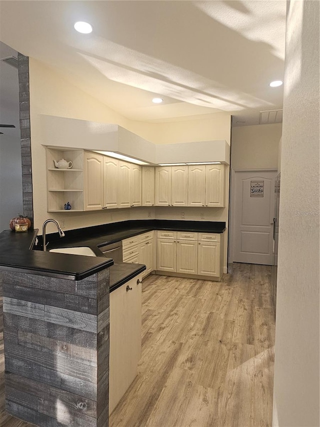 kitchen with sink, kitchen peninsula, light hardwood / wood-style flooring, and dishwasher