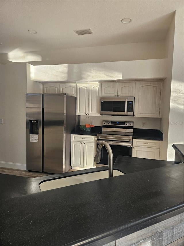 kitchen featuring hardwood / wood-style flooring and appliances with stainless steel finishes