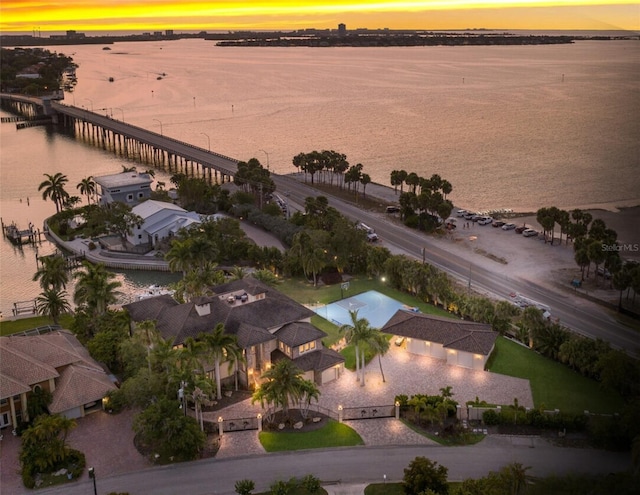 aerial view at dusk featuring a water view