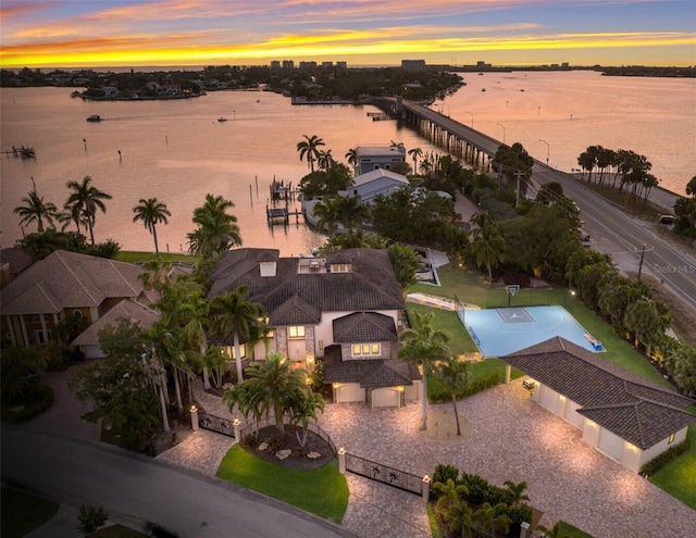 aerial view at dusk featuring a water view