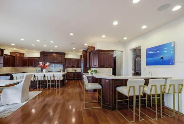 kitchen featuring tasteful backsplash, a large island, dark hardwood / wood-style flooring, and a breakfast bar