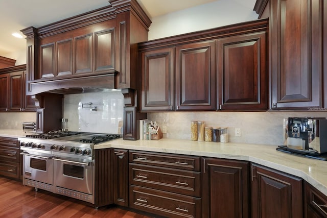 kitchen featuring custom range hood, double oven range, dark hardwood / wood-style flooring, and backsplash