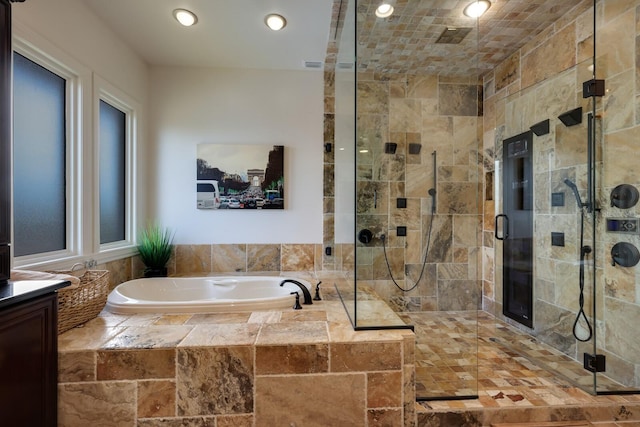 bathroom featuring plus walk in shower and vanity