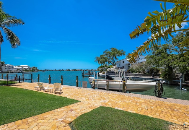 dock area with a lawn and a water view