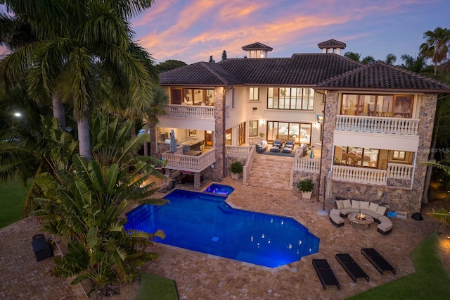 pool at dusk featuring a patio area and a fire pit