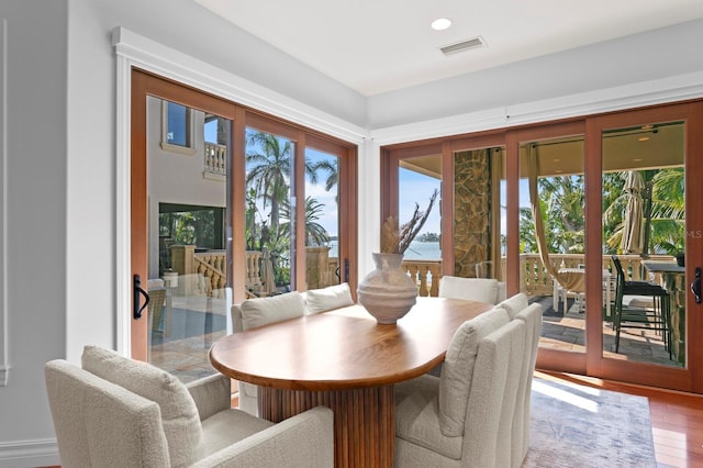 dining room featuring a water view and hardwood / wood-style floors