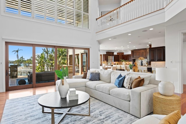 living room with a high ceiling and light wood-type flooring