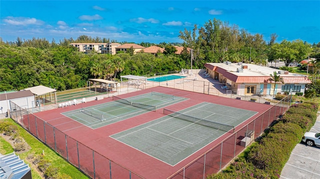 view of tennis court featuring a community pool