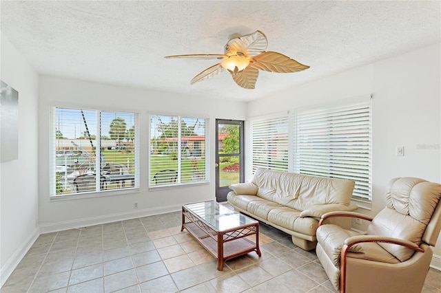 living room with plenty of natural light, ceiling fan, and light tile flooring