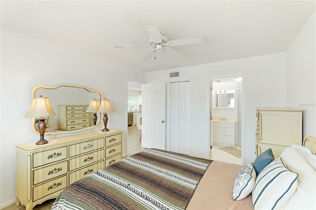 bedroom with tile flooring, ceiling fan, ensuite bathroom, and a closet