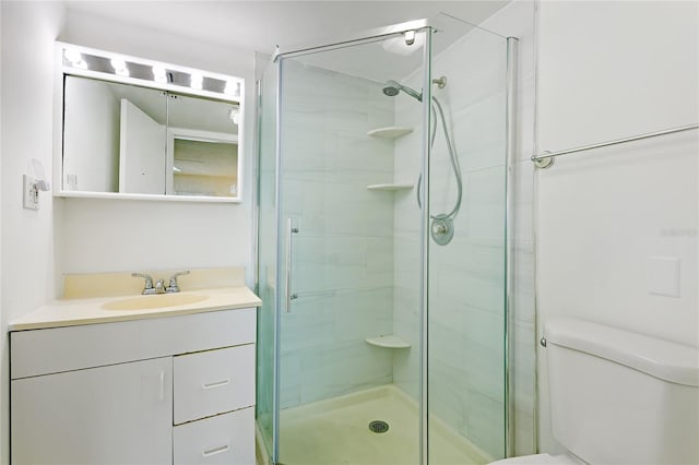 bathroom featuring vanity with extensive cabinet space, an enclosed shower, and toilet