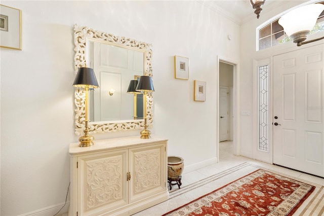 foyer featuring crown molding and light tile floors