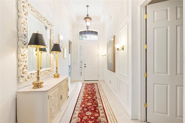 tiled foyer entrance featuring crown molding