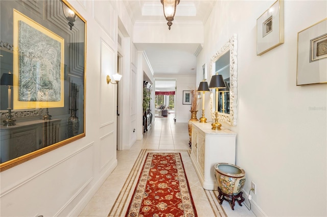 hall featuring light tile patterned floors and crown molding