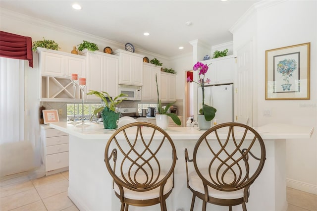 laundry room with crown molding and light tile floors