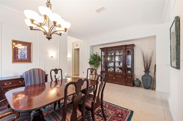 dining room featuring ornamental molding, a notable chandelier, and light tile flooring