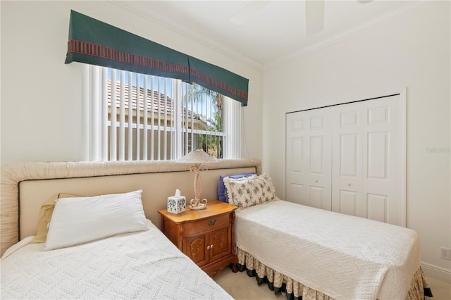 bedroom with crown molding, a closet, light carpet, and ceiling fan