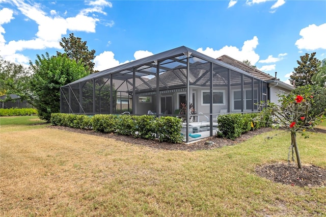 back of house featuring a lanai and a yard