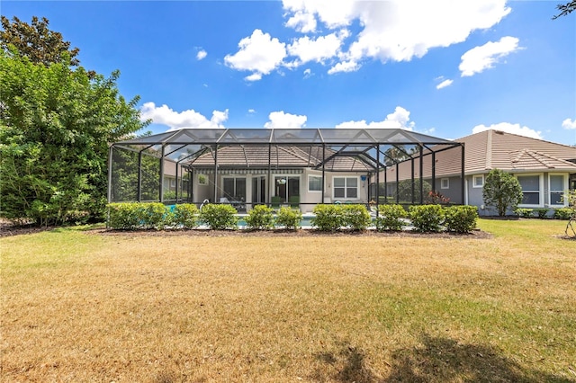 rear view of house featuring glass enclosure and a lawn