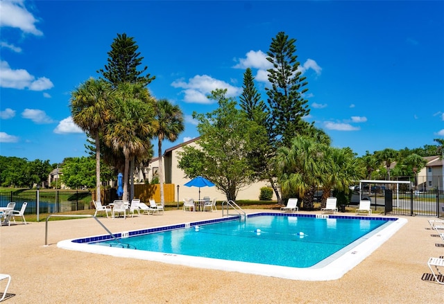 view of pool featuring a patio area and a water view