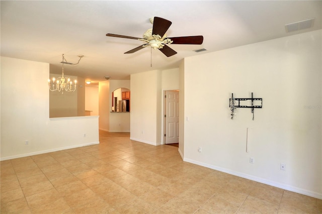 tiled spare room featuring ceiling fan with notable chandelier