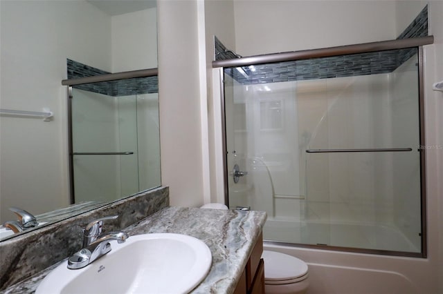 full bathroom featuring enclosed tub / shower combo, vanity, and toilet