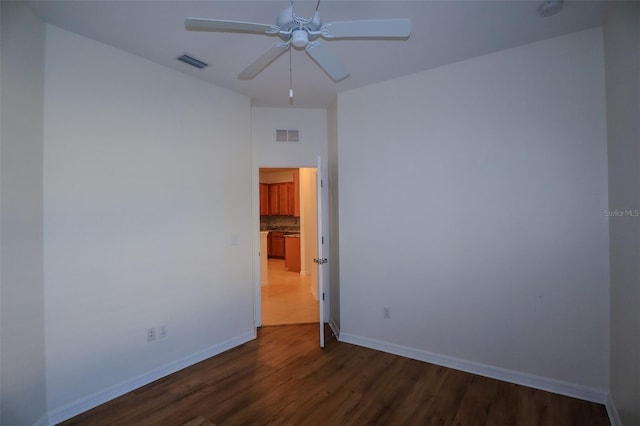 spare room featuring dark wood-type flooring and ceiling fan