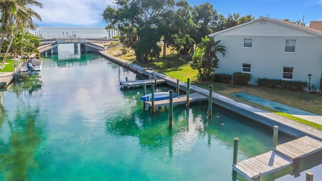 view of pool with a yard, a dock, and a water view