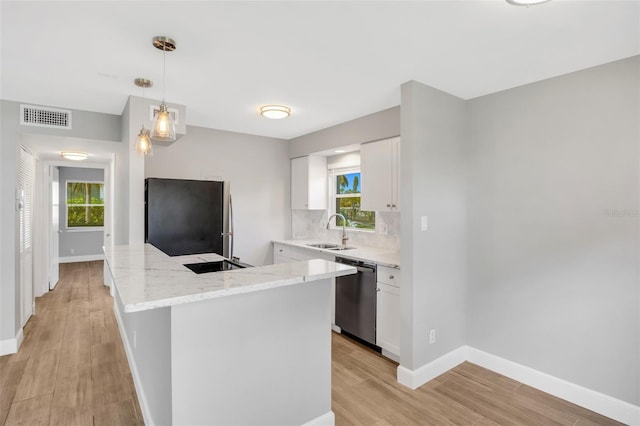 kitchen with pendant lighting, dishwasher, white cabinets, sink, and fridge