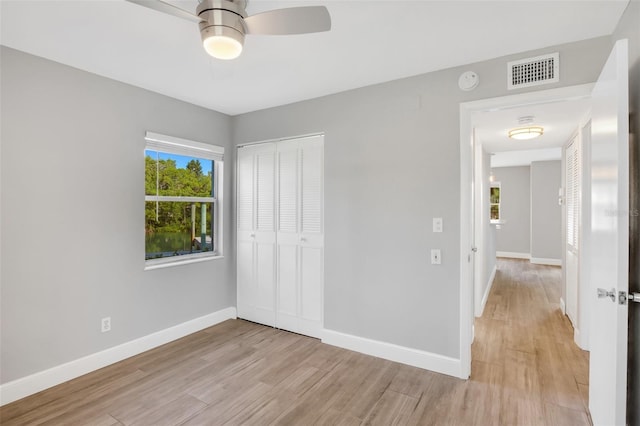 unfurnished bedroom with ceiling fan, light hardwood / wood-style floors, and a closet