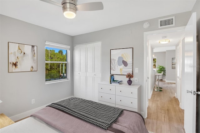 bedroom with ceiling fan, a closet, and light wood-type flooring