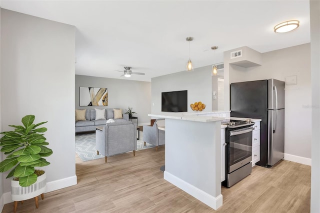 kitchen with kitchen peninsula, stainless steel appliances, ceiling fan, pendant lighting, and a breakfast bar area