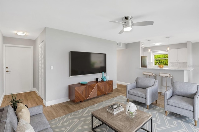 living room featuring light wood-type flooring and ceiling fan