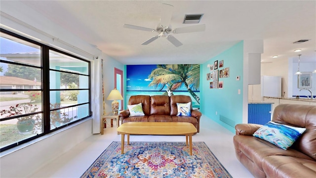 living room featuring ceiling fan, plenty of natural light, and sink