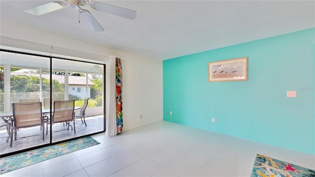 tiled spare room featuring ceiling fan