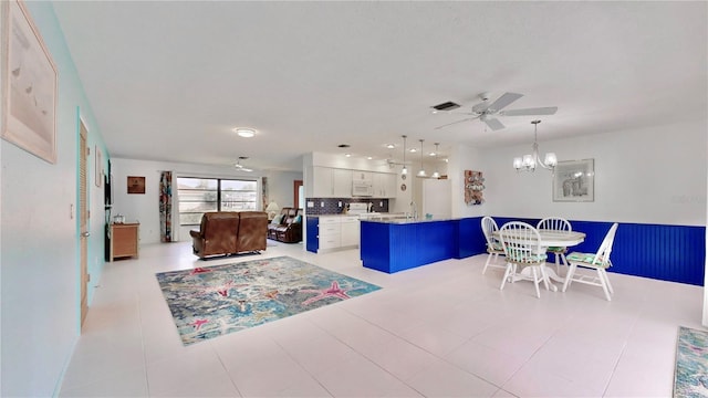 living room with light tile patterned floors and ceiling fan with notable chandelier