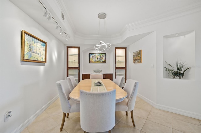 dining area featuring rail lighting, light tile floors, and ornamental molding