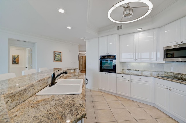 kitchen featuring white cabinets, black appliances, ornamental molding, a raised ceiling, and sink