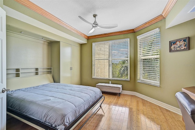 bedroom with wood-type flooring, ceiling fan, and crown molding