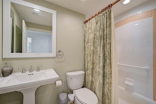 bathroom featuring toilet and shower / bath combo with shower curtain