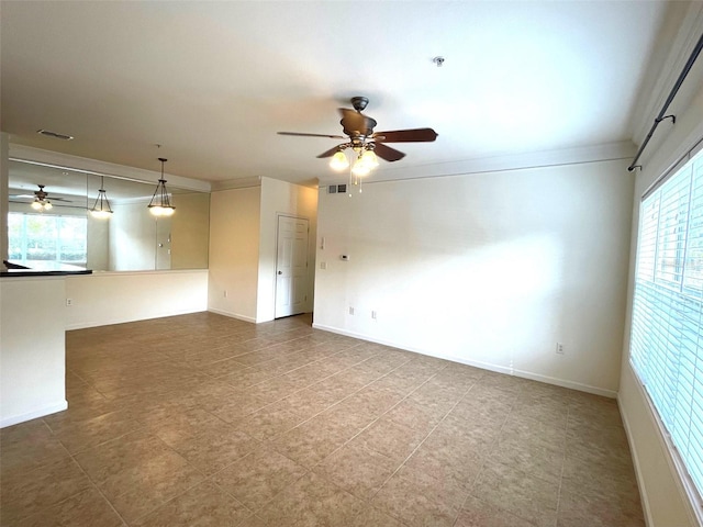 spare room with a wealth of natural light, ceiling fan, and ornamental molding