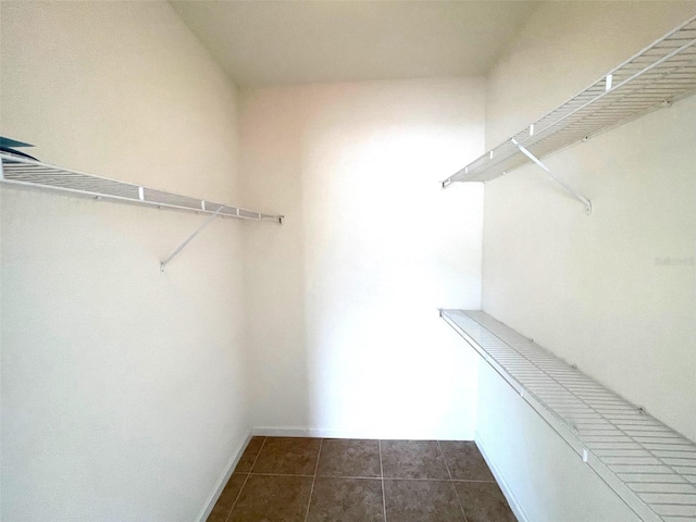 walk in closet featuring dark tile patterned floors