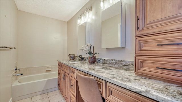 bathroom with a bathing tub, tile patterned flooring, vanity, and a textured ceiling