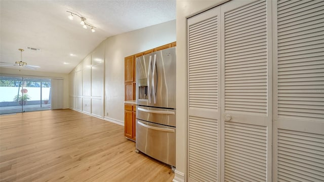 kitchen featuring stainless steel refrigerator with ice dispenser, a textured ceiling, ceiling fan, light hardwood / wood-style floors, and lofted ceiling