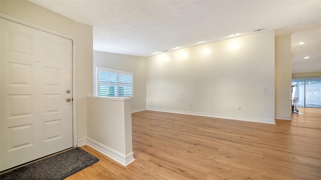 foyer with a textured ceiling and light wood-type flooring