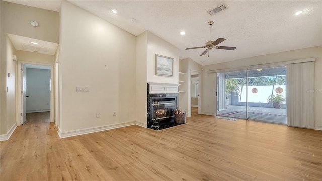 unfurnished living room featuring ceiling fan, light hardwood / wood-style flooring, and a textured ceiling