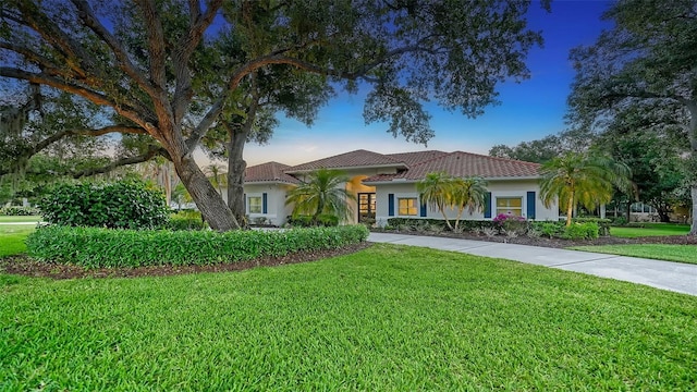 mediterranean / spanish home with a front lawn